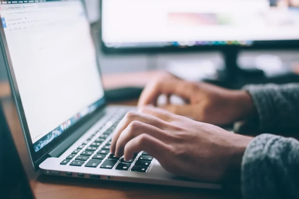 A freelancer working on a laptop with AI tools